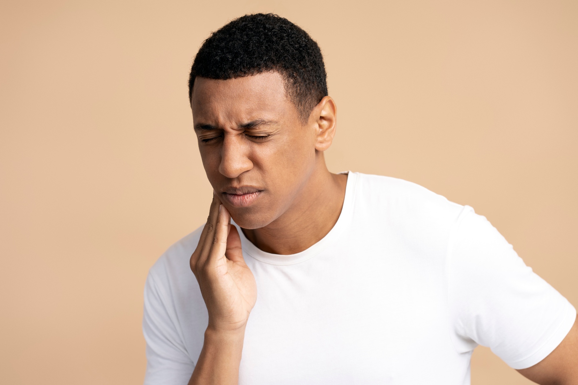 Man experiencing gum pain, highlighting signs of periodontal disease and the importance of gum health, as treated at Shady Grove Periodontics in Rockville, MD.